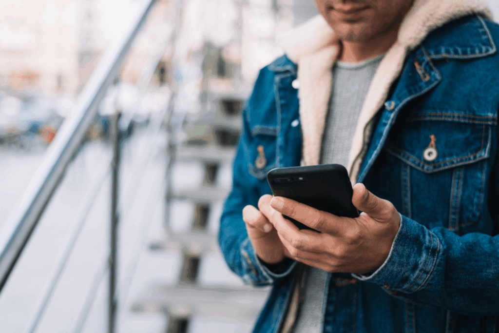 Homem mexendo em um iPhone 16 da Casas Bahia