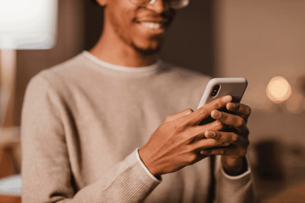 Homem segurando um iPhone da Casas Bahia