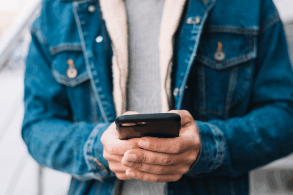 Homem mexendo no iPhone 13 da Casas Bahia