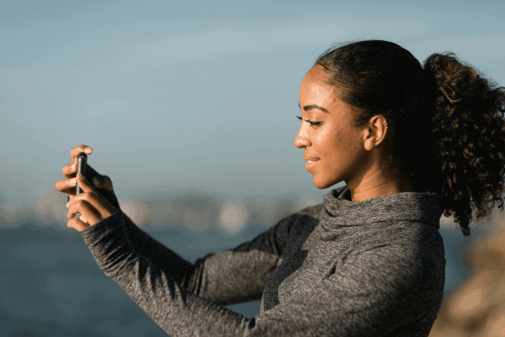 Mulher tirando uma foto com a câmera do iPhone 16 Pro da Casas Bahia