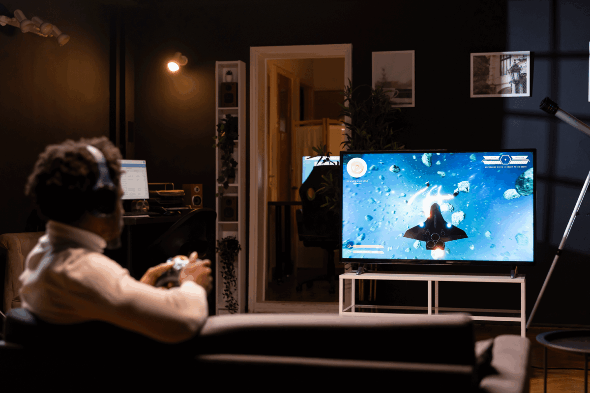 Homem jogando video game na Smart TV da Casas Bahia