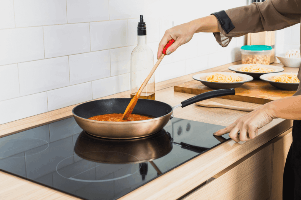 Pessoa cozinhando em um cooktop da Casas Bahia